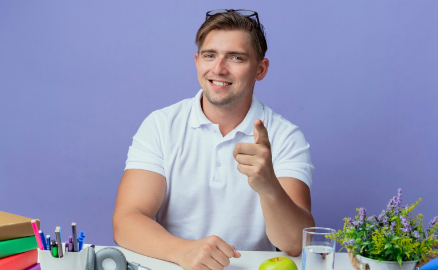Smiling young man pointing confidently while sitting at a desk, symbolizing trust in certified, third-party tested supplements.