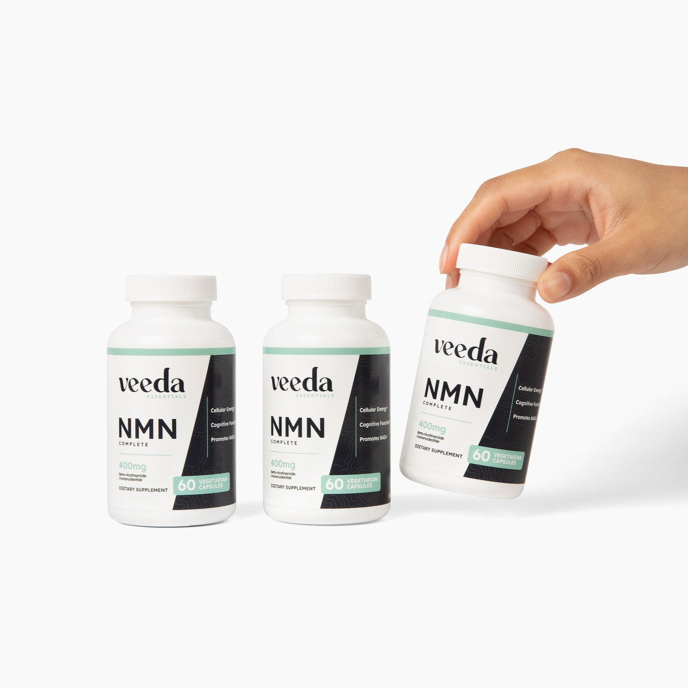 Three bottles of 'veeda NMN' supplement on a white background